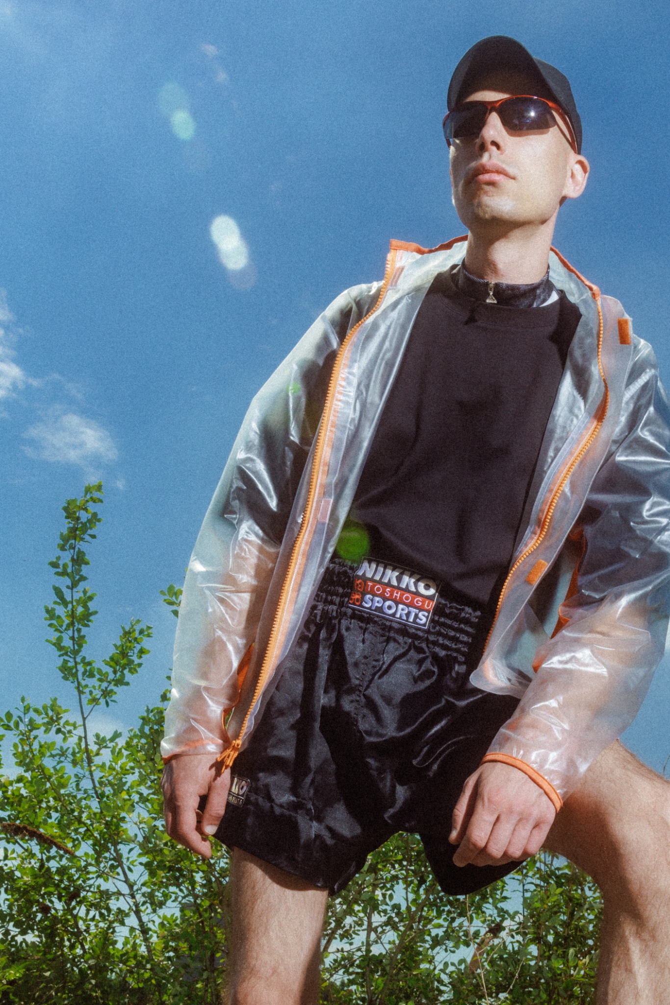 Portrait of umbraid wearing a translucent jacket against a blue sky